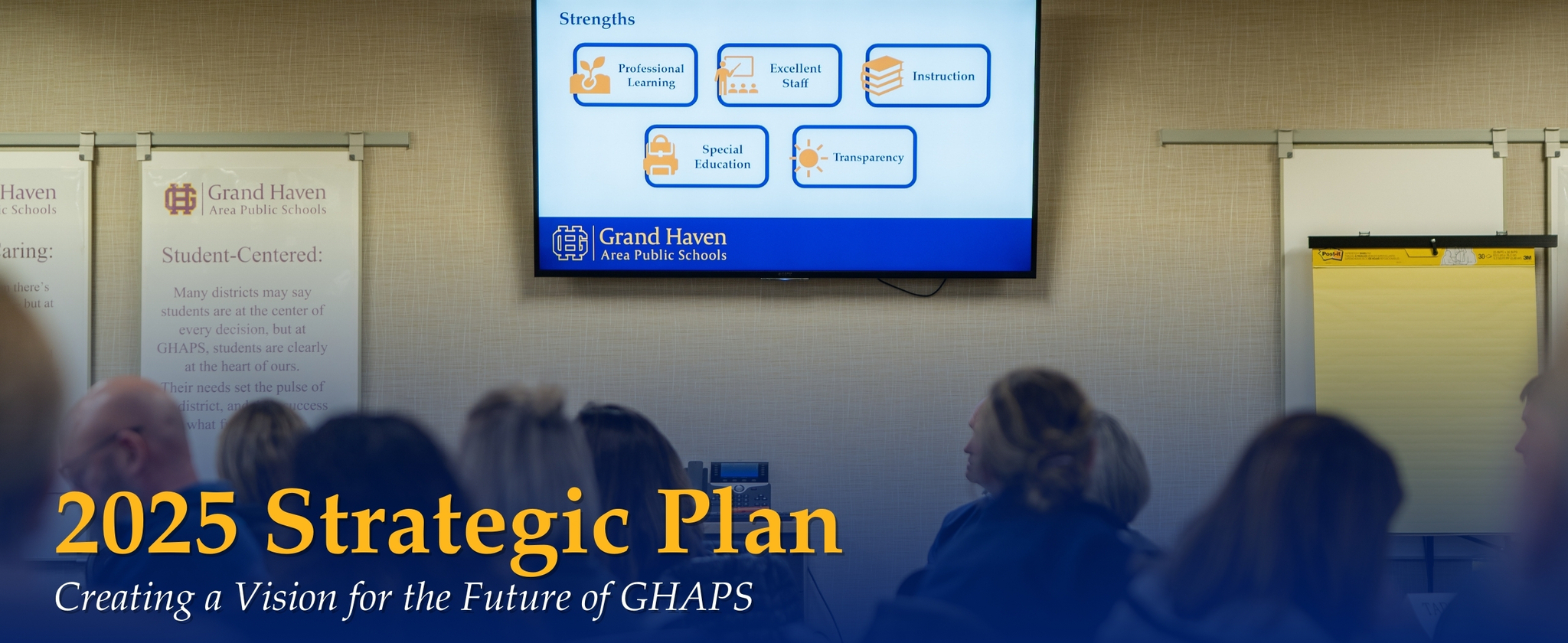Members of the strategic plan working group viewing a screen that lists the strengths of the district, and the following text : 2025 Strategic Plan, Creating a Vision for the Future of GHAPS