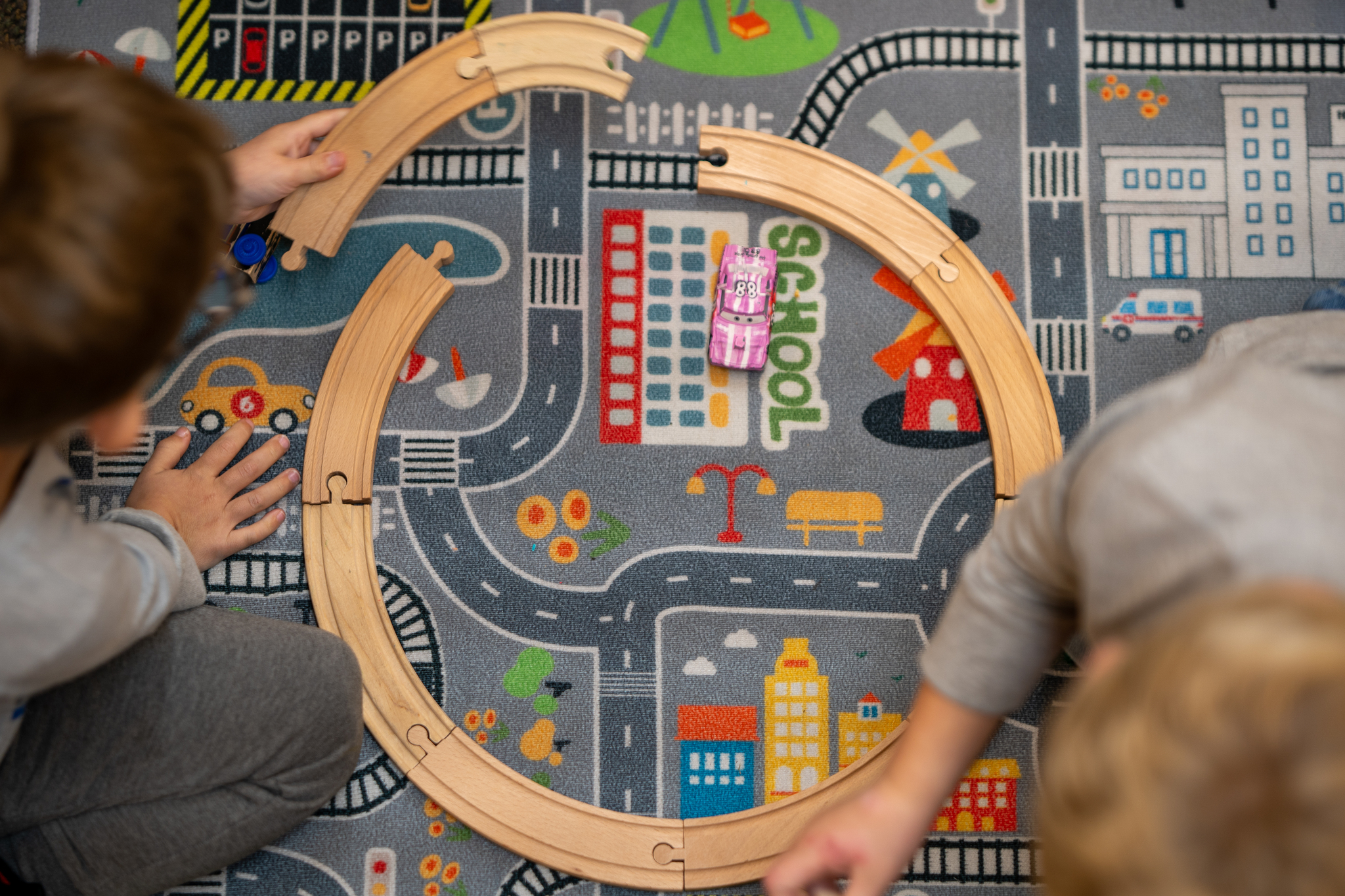 Overhead view of two children playing with a train set